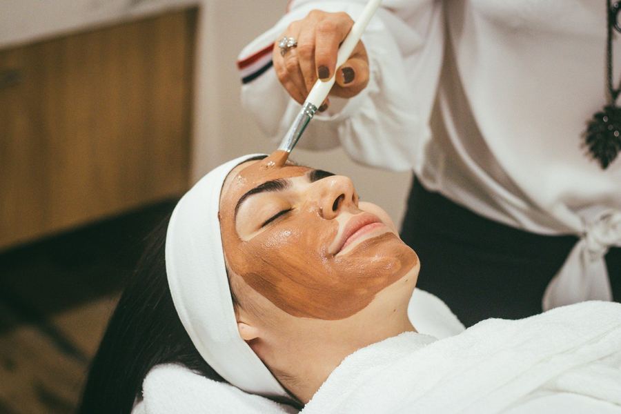 A client receiving a clay mask during a facial